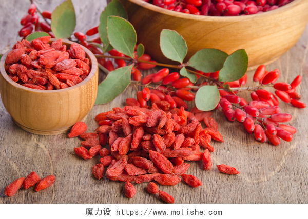 桌子上的红色枸杞小檗和干枸杞浆果在碗上木制背景
